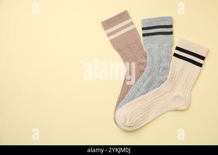 Verschiedene bequeme Socken auf beigefarbenem Hintergrund, flach geschnitten. Leerzeichen für Text Stockfoto