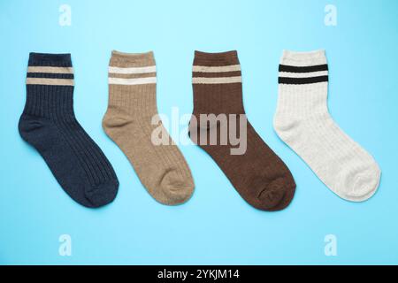 Verschiedene bequeme Socken auf hellblauem Hintergrund, flach geschnitten Stockfoto