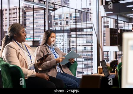 Weibliche Beamte in einem Unternehmensumfeld teilen große Ideen und Strategien für die Karriereentwicklung und erreichen Ziele. Multikulturelles Team als Beispiel für Führung und Frauenbefähigung. Stockfoto