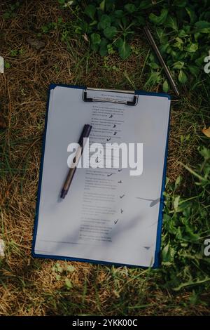 Checkliste mit Stift auf der Zwischenablage im Freien in natürlicher Umgebung Stockfoto