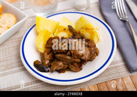 Gebratene Hühnerleber mit Zwiebeln und gebackenen Kartoffeln Stockfoto