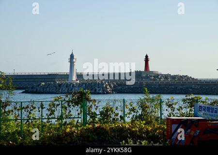 Sokcho, Südkorea - 3. November 2024: Blick auf die rot-weißen Leuchttürme, die sich auf dem Wellenbrecher am Daepo Port befinden und als Navigations-la stehen Stockfoto