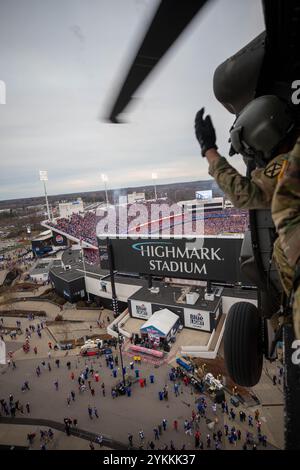 Sgt. Ante Vanjak aus Brooklyn, New York, ein Crewchef, der dem 3. General Support Aviation Battalion, 10. Combat Aviation Brigade, 10. Mountain Division, zugeteilt wurde, winkt den Fans beim Flug über das Highmark Stadium während der Nationalhymne in Brooklyn, New York, 17. November 2024. Im Rahmen eines Community-Engagements flogen zwei Sikorsky UH-60 Black Hawks und zwei Boeing AH-64 Apaches, die vom 10. TAXI geschickt wurden, über das Spiel Buffalo Bills vs. Kansas City Chiefs. (Foto der US-Armee von SPC. Elijah Campbell) Stockfoto