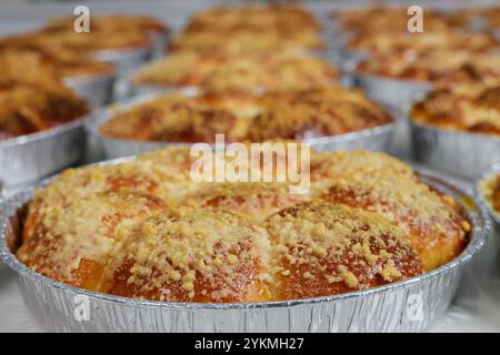 Frisch gebackenes goldenes Gebäck in Metallblechen in der Bäckerei in den frühen Morgenstunden Stockfoto