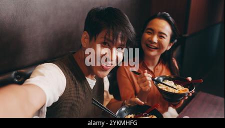 Paare, Porträt und Selfie mit Essen im Restaurant, Bonding und Feier zum Jubiläum mit einem Lächeln. Japaner, Mann und Frau mit Freude Stockfoto