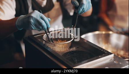 Japanisches Restaurant, Kochen und handkochende Nudeln in der Küche für traditionelle Küche, kulinarische Kultur und Zubereitung von Mahlzeiten. Koch, Handschuhe und Dampfgarer Stockfoto