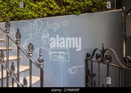 Kinderkreidezeichnungen an der grauen Wand eines Hauses in Sydney, Australien. Stockfoto