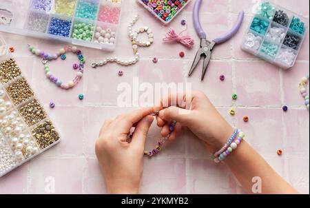 Kind kreiert handgemachten Schmuck und genießt ein entspannendes Hobby Stockfoto