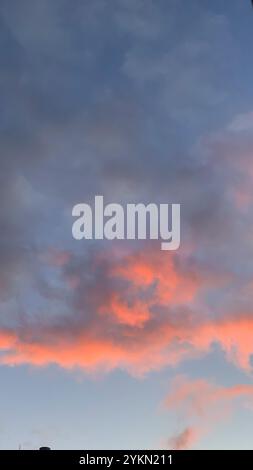 Wunderschöner blauer Himmel mit einer rosafarbenen Wolke in der Mitte. Der Himmel ist klar und die Sonne untergeht Stockfoto