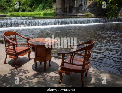 Ein Sessel am Flussufer zum Entspannen und Genießen von Speisen und Getränken am Nachmittag. Stockfoto