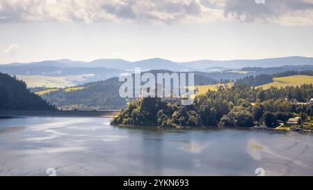 Das Schloss Dunajec liegt eingebettet in sanfte Hügel und blickt auf den ruhigen Fluss, der von Sonnenlicht in Polen getaucht ist Stockfoto