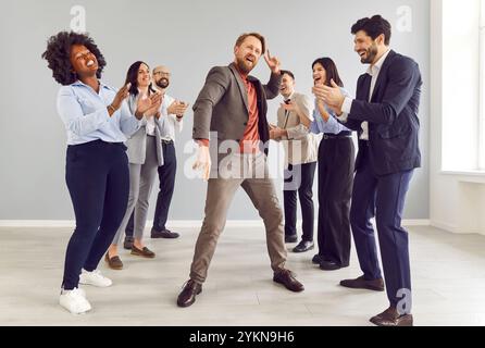 Büro enthusiastischer Spaß, Tanz glücklicher männlicher Arbeiter wurde befördert, um Erfolg zu feiern, zu bezahlen Stockfoto