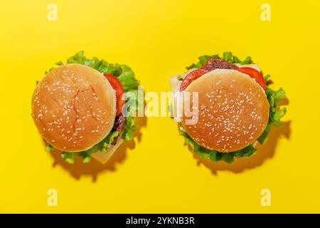 Ein lebhaftes Foto mit saftigen Cheeseburgern, die eine lustige und appetitliche Szene schaffen Stockfoto