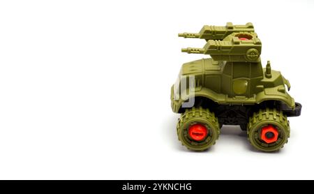 Kinderspielzeugauto in der Form Eines Militärkriegspanzers in grüner Farbe auf weißem Hintergrund isoliert, fotografiert mit Komposition Leaving Space on the Stockfoto