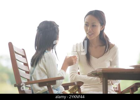 Mutter und Tochter essen im Park Stockfoto