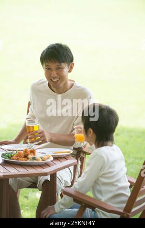 Vater und Sohn essen im Park Stockfoto