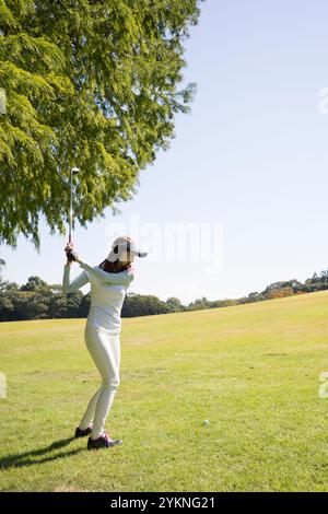 Eine Frau in ihren 20s, die Golf spielt Stockfoto