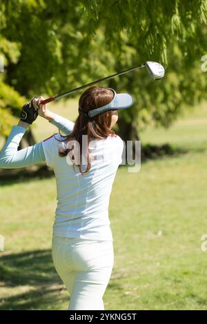 Eine Frau in ihren 20s, die Golf spielt Stockfoto