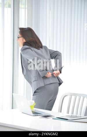 Geschäftsfrau steht und dehnt ihre Taille Stockfoto