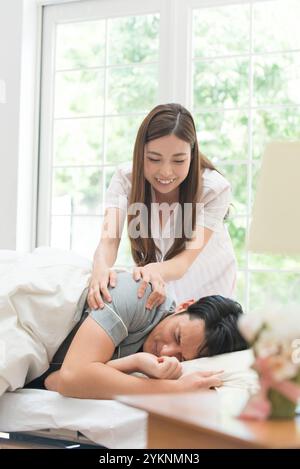 Frau im Schlafanzug, die schlafenden Mann aufwacht Stockfoto