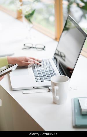 Frau Hand am Computer auf der Fensterbank Stockfoto