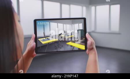 Asiatische Designerin verwendet Tablet-Computer und Augmented Reality-Software für die Innenarchitektur, um ein Büro zu bauen. Der Tablet-Bildschirm zeigt den Scanraum der KI-Builder-App und erstellt Design mit 3D-Möbelobjekten. Stockfoto