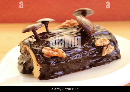 Köstlicher hausgemachter Schokoladen-Yule-Baumkuchen mit Pilzen-Dekoration zu Weihnachten Stockfoto