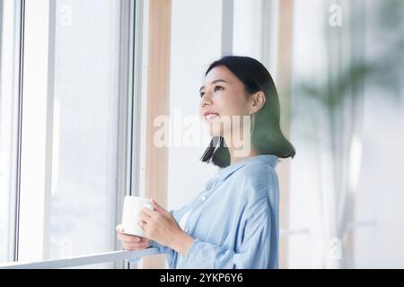 Frau, die sich im Zimmer erholt Stockfoto