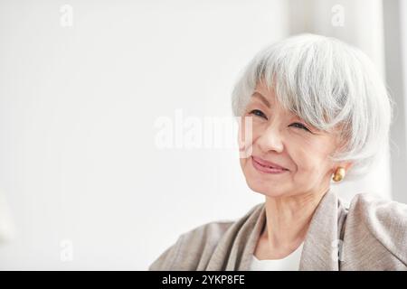 Seniorin öffnet Vorhänge Stockfoto