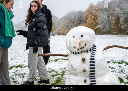 Oxford Brookes Studenten, (l-r) Abie, Jade, Cole und Felicity erwachten von der Überraschung eines frühen Schneefalls im November. Sie machten sich auf den Weg zum South Park, der die berühmten Türme von Oxford überblickt, um im Schnee zu spielen. Zusammen bauten sie einen Schneemann, fügten Stöcke für Arme, Steine für Augen und Knöpfe hinzu, eine Karottennase und natürlich einen Schal, um ihre Kreation warm zu halten. Stockfoto