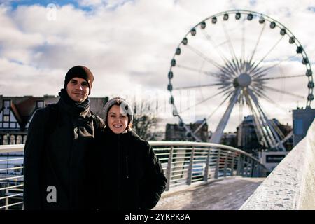Das junge Paar umarmt sich vor dem Riesenrad in Gdańsk Stockfoto
