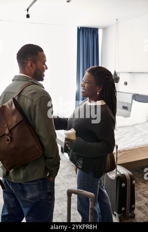 Ein junges afroamerikanisches Paar genießt ihren gemeinsamen Urlaub, indem es ein Lächeln und Liebe in einem Hotelzimmer teilt. Stockfoto