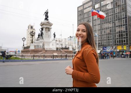 Porträt einer lächelnden jungen Frau, die die Plaza Sotomayor in Valparaiso, Chile besucht Stockfoto