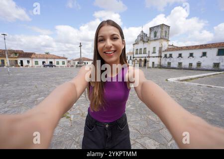 Das schöne Touristenmädchen macht Selfie auf dem Sao Francisco Platz in Sao Cristovao Stadt, Sergipe, UNESCO-Weltkulturerbe, Brasilien Stockfoto