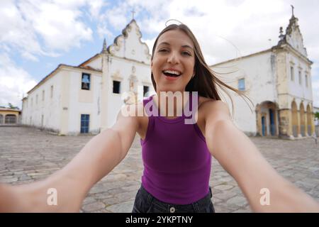 Die schöne junge Frau fotografiert Selbstporträts in Praca do Carmo im Dorf Sao Cristovao, Sergipe, Brasilien Stockfoto