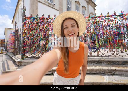 Das Traveler Girl macht Selfie vor der Kirche unseres Herrn von Bonfim voller bunter Bänder in Salvador de Bahia, Brasilien Stockfoto