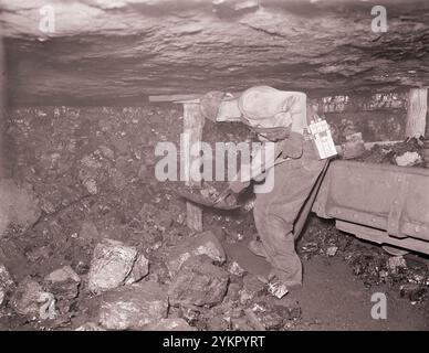 Vintage-Foto von amerikanischen Bergleuten. Harry Fain lädt Kohle, die gerade aus dem Gesicht geschossen wurde. Er wird etwa 16-17 Tonnen pro Tag beladen. Inland Steel Company, Wheelwright #1 & 2 Mines, Wheelwright, Floyd County, Kentucky. USA. September 1946 Stockfoto