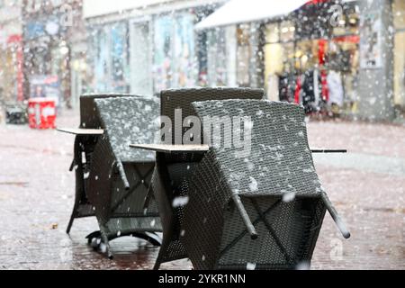 Hamburg, Deutschland. November 2024. Tische und Stühle mit hoher Lehne stehen in der Fußgängerzone im Schneefall. Quelle: Bodo Marks/dpa/Alamy Live News Stockfoto