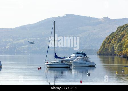 Boote auf Loch Lomond mit einem touristischen Wasserflugzeug in der Ferne Balmaha, Stirling, Schottland Stockfoto