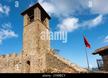 Historische Wahrzeichen der Preza Festung Albanien. Uhrenturm von Schloss Preze, Tirana mit albanischer Flagge auf blauem Himmel Hintergrund. Tourismus-Tram Stockfoto