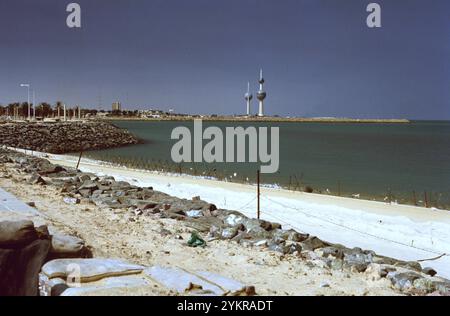 Erster Golfkrieg: 11. März 1991 die berühmten Kuwait Towers stehen im Hintergrund hinter dem Strand von Ali Baba in Kuwait City. Die irakische Armee erwartete, dass die Koalitionstruppen vom Meer aus einmarschieren, und setzte Stacheldraht und Anti-Landungsboote entlang des Strandes und in die Untiefen. Auch die Strände wurden abgebaut. Stockfoto