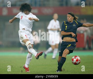 TIANJIN, CHINA - 6. AUGUST: Han Duan von China (l) schießt gegen Schweden, als Sara Larsson (r) während eines Gruppenspiels beim Olympischen Frauenfußballturnier in Peking am 6. August 2008 in Tianjin, China verteidigt. Nur redaktionelle Verwendung. (Foto: Jonathan Paul Larsen / Diadem Images) Stockfoto