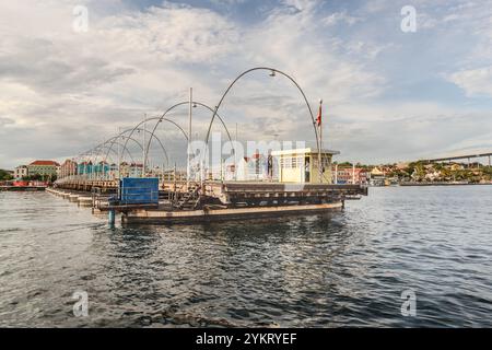 Die Queen Anna Bridge heißt Swinging Old Lady. Diese 1888 Ponton-Fußgängerbrücke öffnet sich seitlich für vorbeifahrende Schiffe. Handelskade, Willemstad, Curacao. Seit 1974 können Autos die Bucht von St. Anna über die Queen Juliana Bridge (im Hintergrund) überqueren, Kòrsou Stockfoto