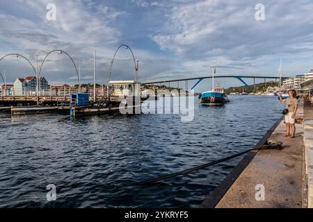 Die Queen Anna Bridge heißt Swinging Old Lady. Diese 1888 Ponton-Fußgängerbrücke öffnet sich seitlich für vorbeifahrende Schiffe. Handelskade, Willemstad, Curacao. Seit 1974 können Autos die Bucht von St. Anna über die Queen Juliana Bridge (im Hintergrund) überqueren, Kòrsou Stockfoto