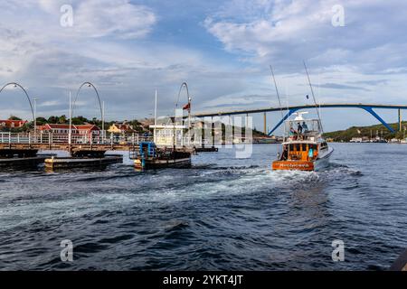 Die Queen Anna Bridge heißt Swinging Old Lady. Diese 1888 Ponton-Fußgängerbrücke öffnet sich seitlich für vorbeifahrende Schiffe. Handelskade, Willemstad, Curacao. Seit 1974 können Autos die Bucht von St. Anna über die Queen Juliana Bridge (im Hintergrund) überqueren, Kòrsou Stockfoto