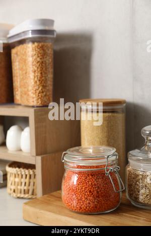 Verschiedene Arten von Getreide und Hülsenfrüchten in Behältern auf dem Tisch Stockfoto