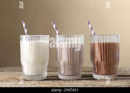 Verschiedene leckere Proteincocktails in Gläsern auf Holztisch Stockfoto