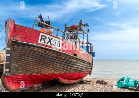 Rotes und braunes Holzfischboot am Strand von Hastings im Sommer (X58 RX58) Stockfoto