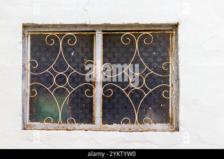 Antike Eisengitter an rustikalen Fenstern mit dekorativem Design Stockfoto