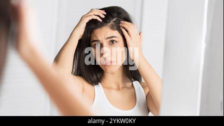 Mädchen auf der Suche nach Haare Flocken im Spiegel im Badezimmer, Panorama Stockfoto